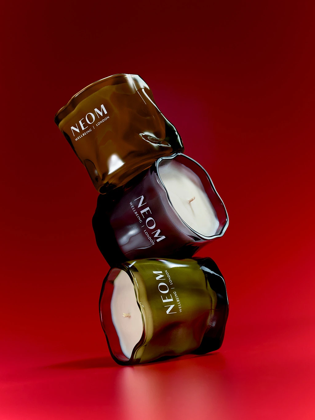 Stack of three scented neom candles.
