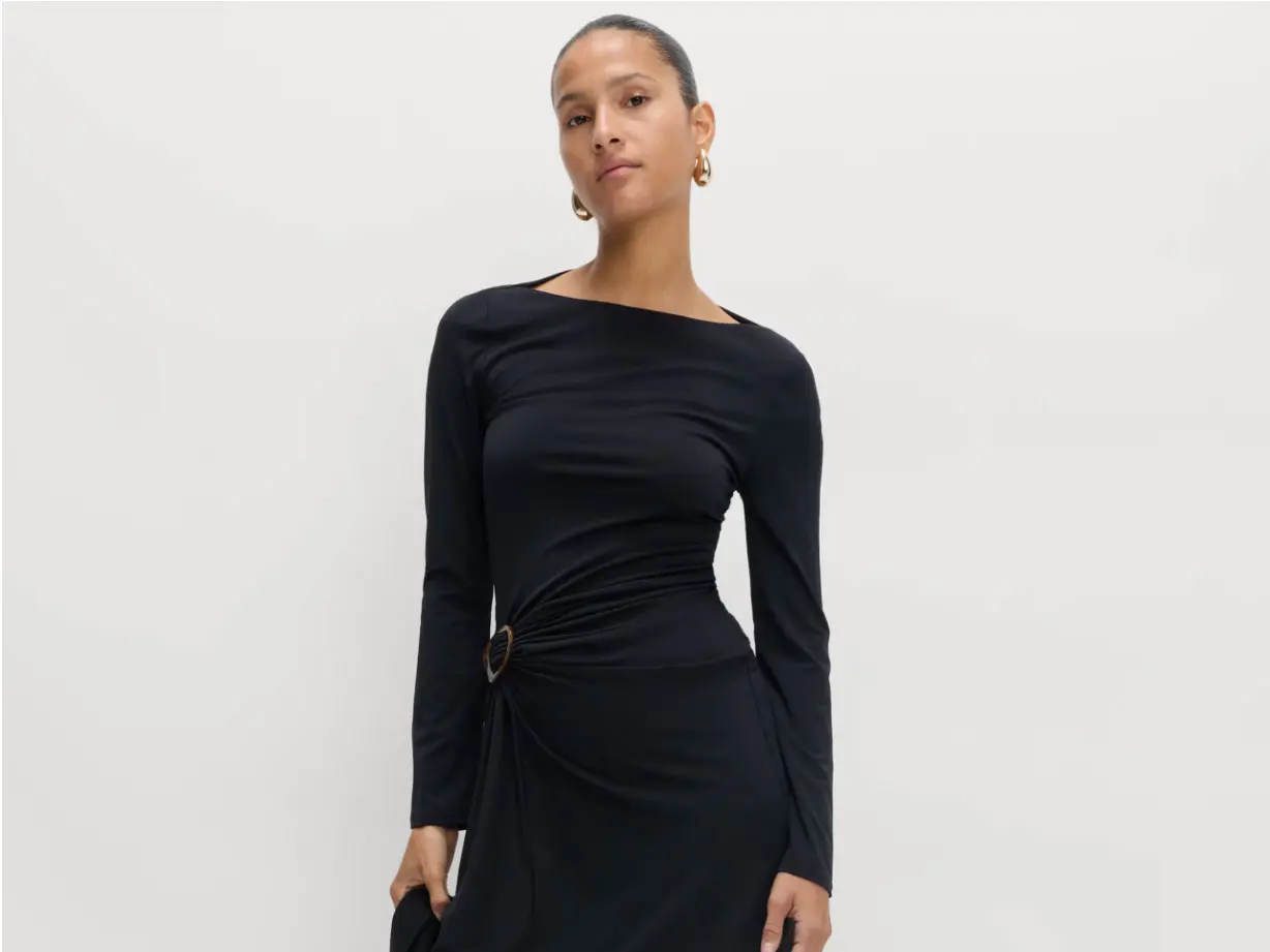 Woman wearing little black dress with gold earrings