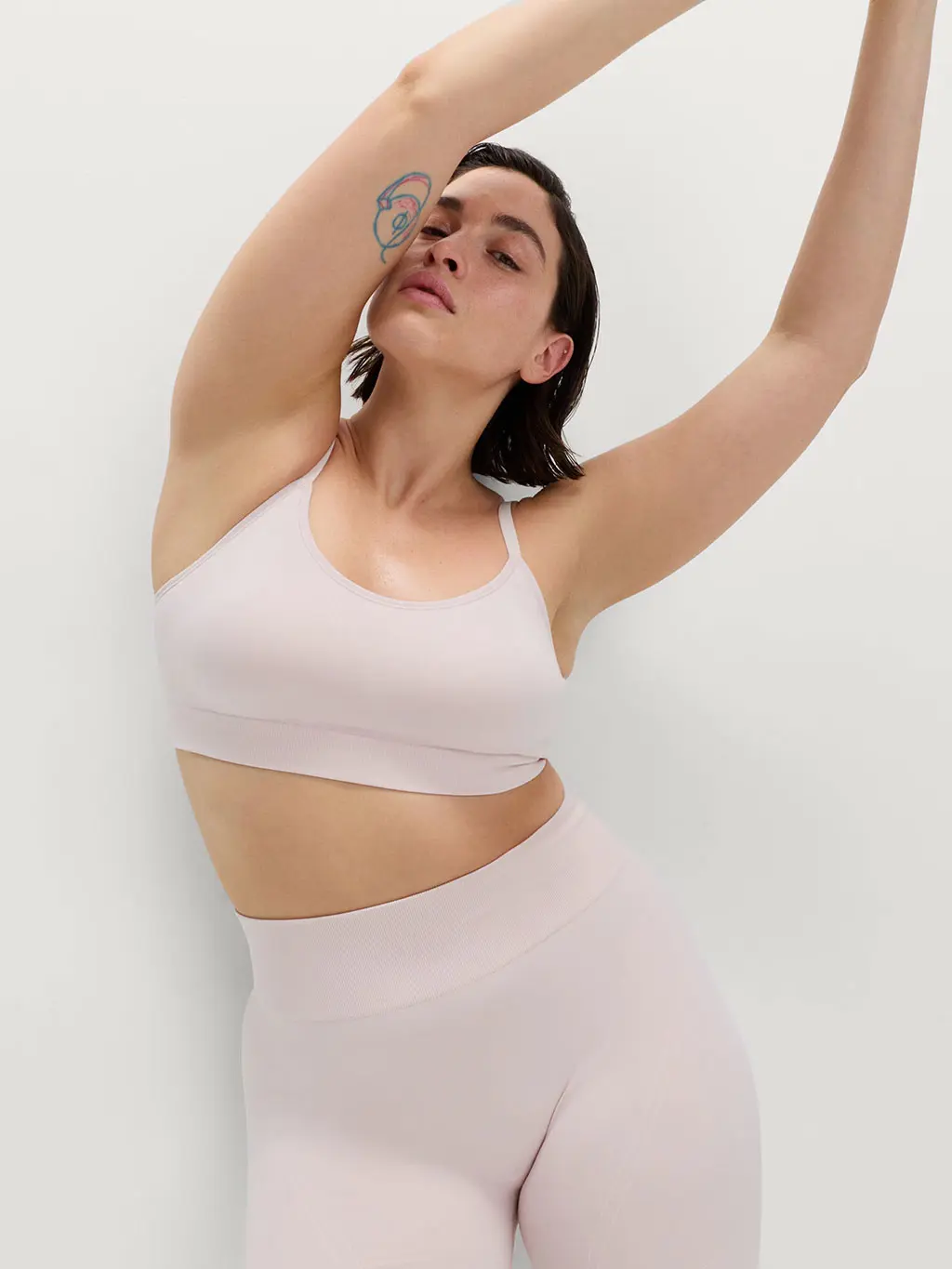 Woman wearing dusty pink low-impact sports bra and leggings