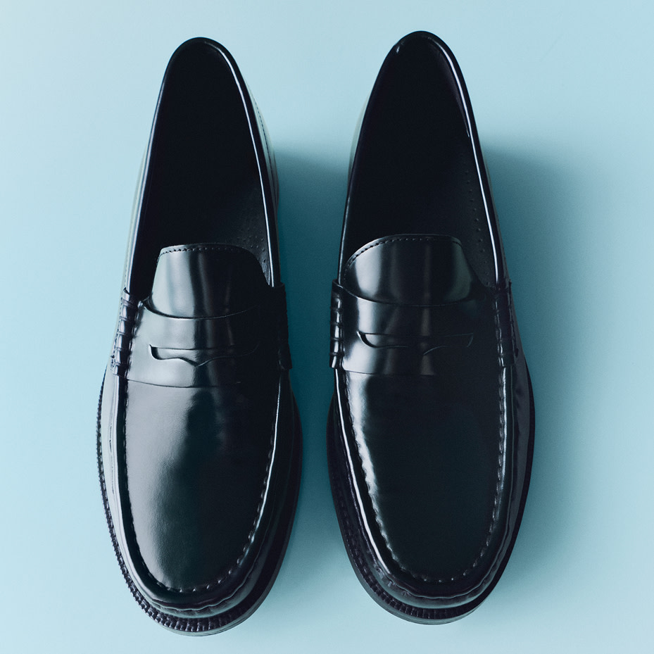 Black loafers on blue background