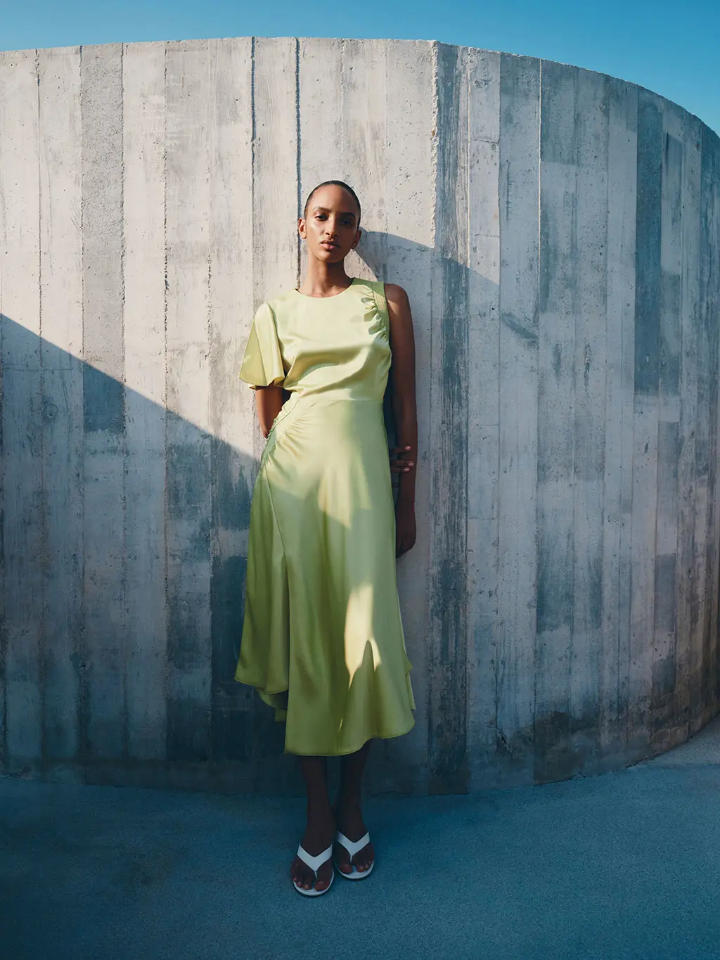 Woman in green satin dress with white sandals