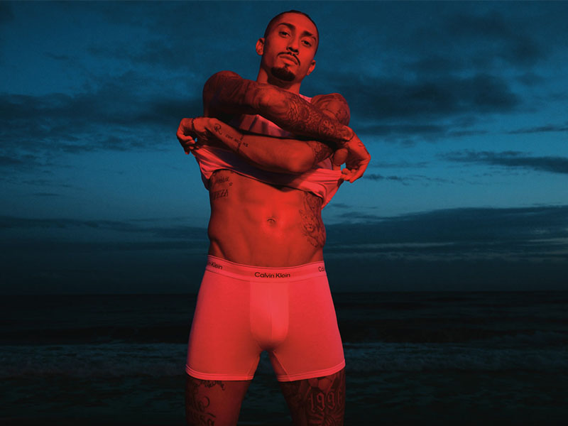 man wearing boxers and taking off white vest