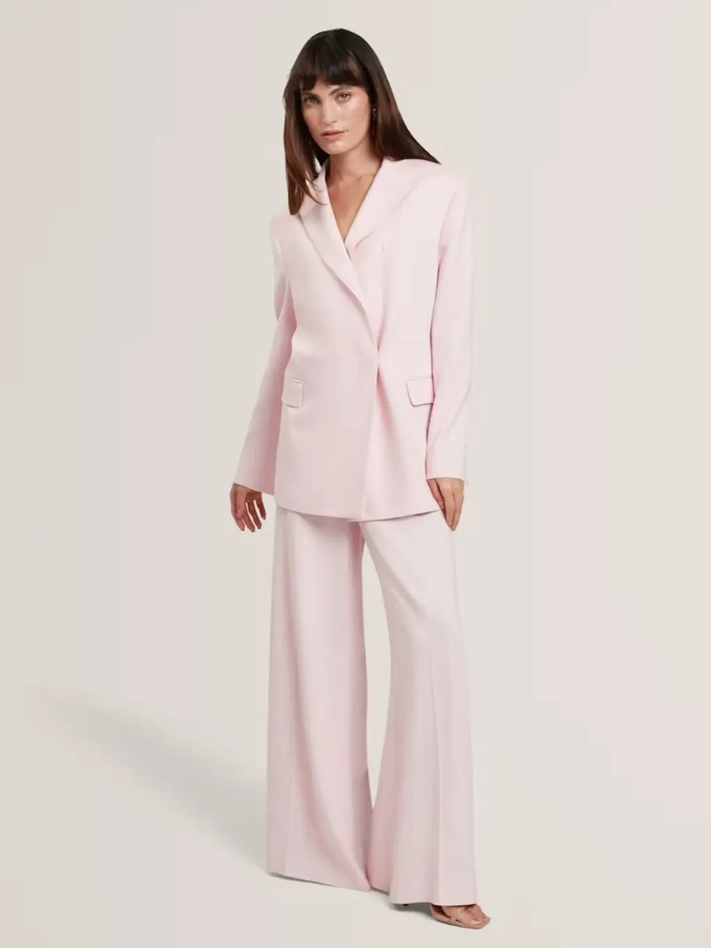 A woman wears a pink suit by Ted Baker