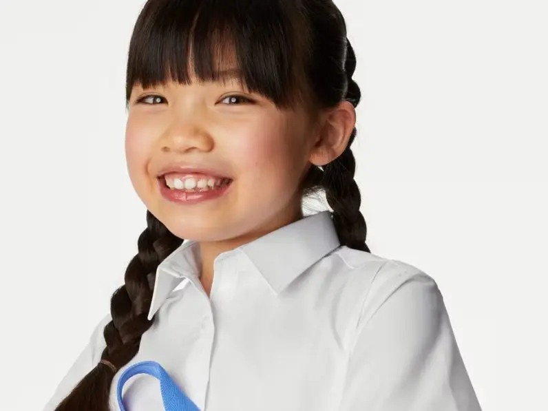 A girl smiling in a shirt made with rip-tape fastenings for easy dressing