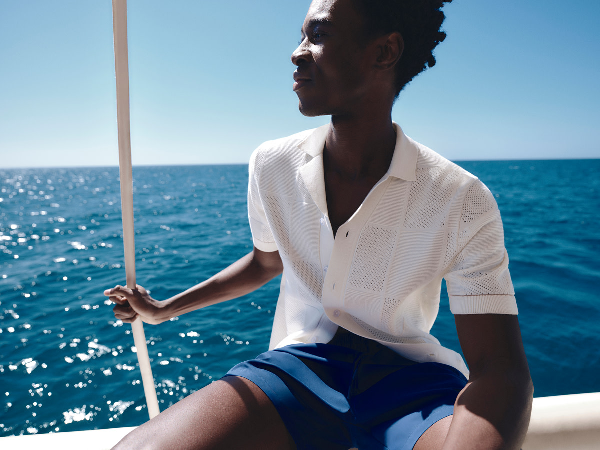 Man wearing white casual shirt and blue shorts on a boat