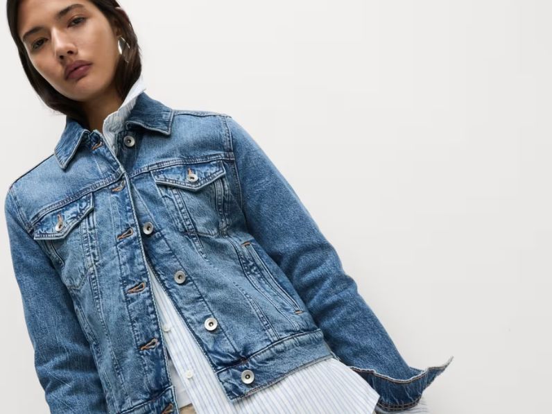 A woman wearing a blue denim jacket over a striped shirt