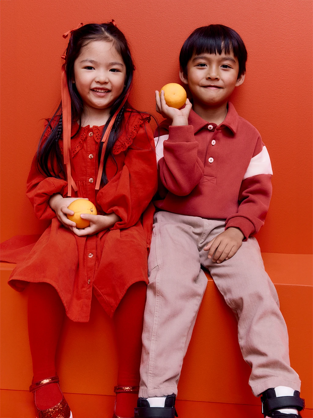 Girl and boy wearing red outfits to celebrate Lunar New Year 2025