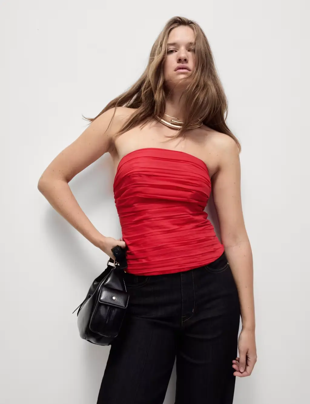 Plus-size woman wearing a red top and black leather trousers with heels for New Year's Eve