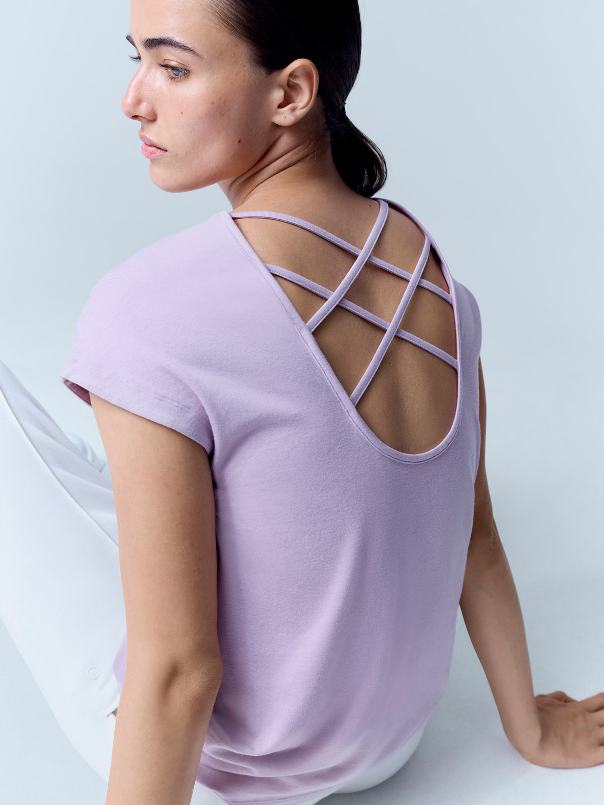 Woman wearing lilac cross-back yoga top