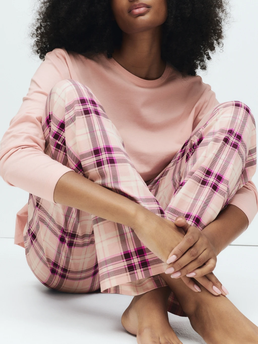 Woman wearing pink cotton checked pyjamas
