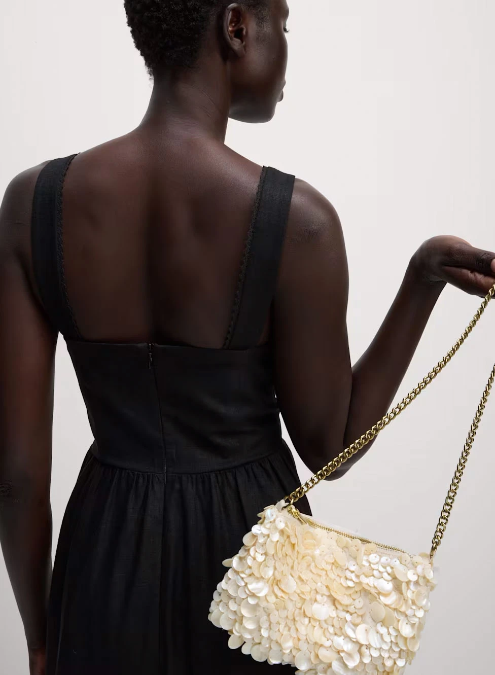 Woman carrying cream sequinned bag