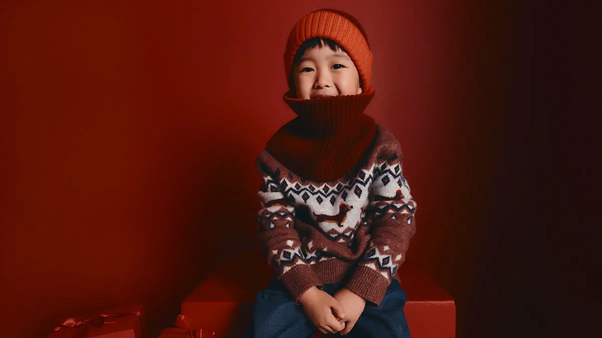 Child wearing festive jumper and beanie 