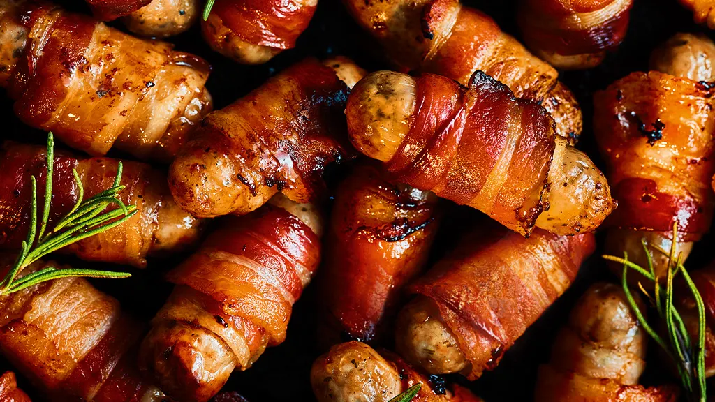 Close up of pigs in blankets and sprigs of rosemary