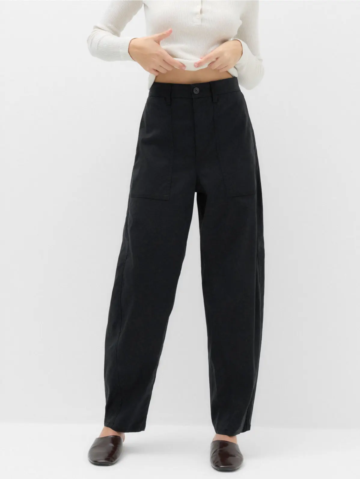 Woman wearing black barrel-leg trousers