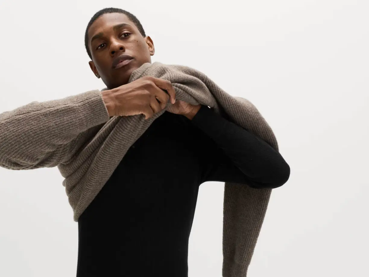 Man wearing neutral jumper over black long-sleeve thermal top 