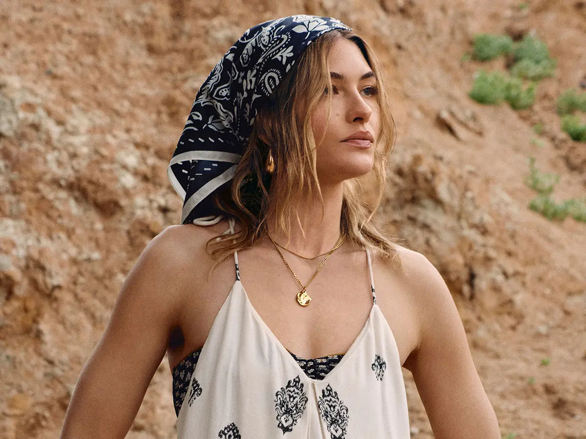 Woman wearing white dress and printed headscarf 