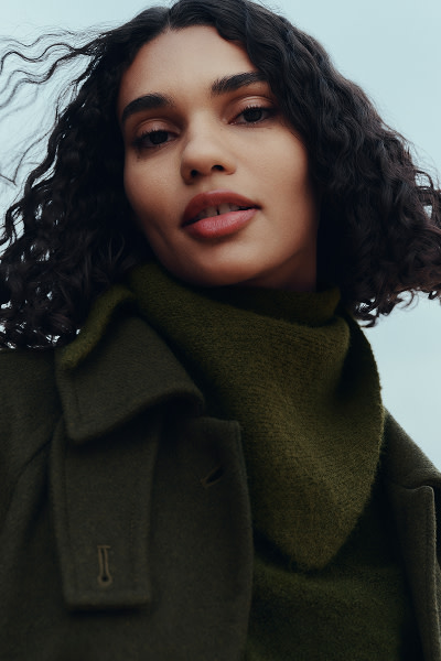 Woman wearing green coat & jumper