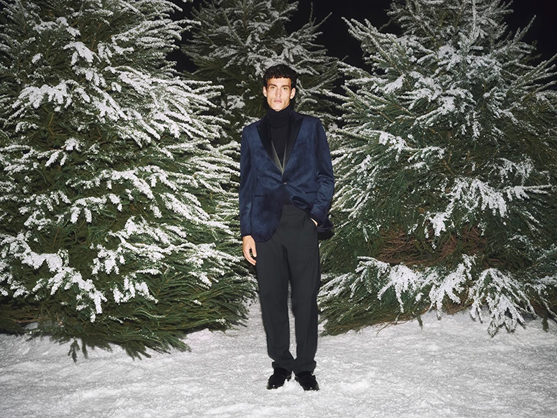 Man wearing navy velvet tuxedo suit and a black roll-neck sweater