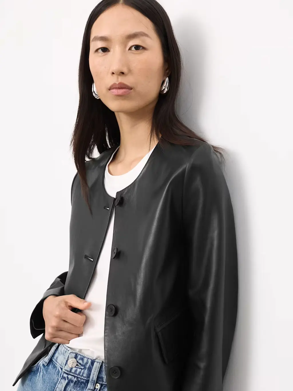 Woman wearing a black leather jacket over a white T-shirt with jeans