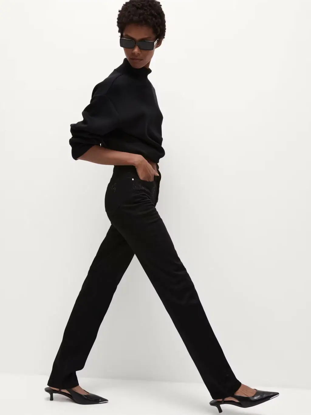Woman wearing a black shirt with black straight-leg jeans and sling-back heels