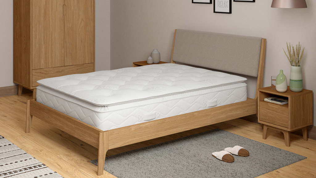 Image of a white mattress on a wooden bedframe. Shop furniture savings