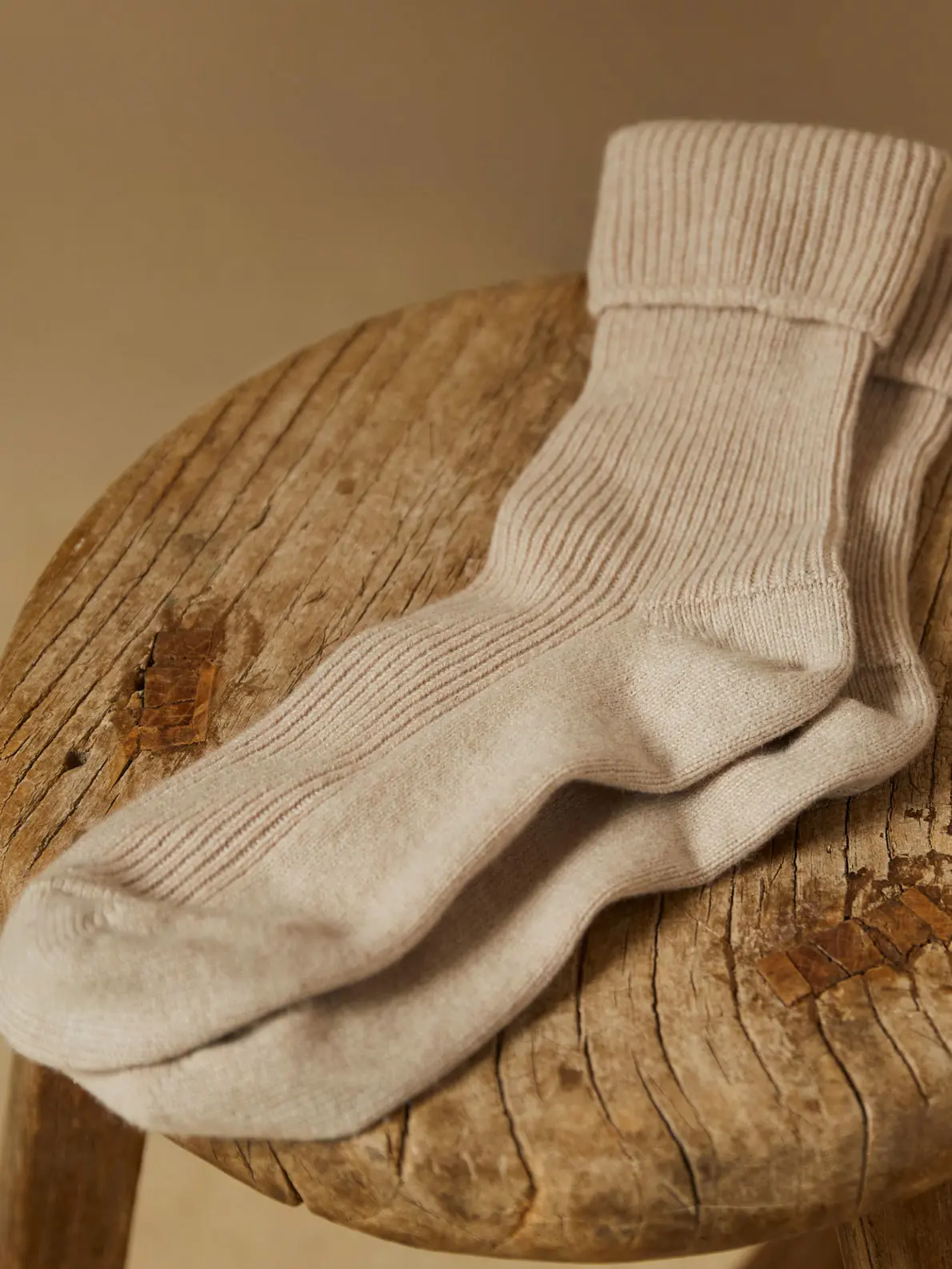 Pair of beige socks on wooden table