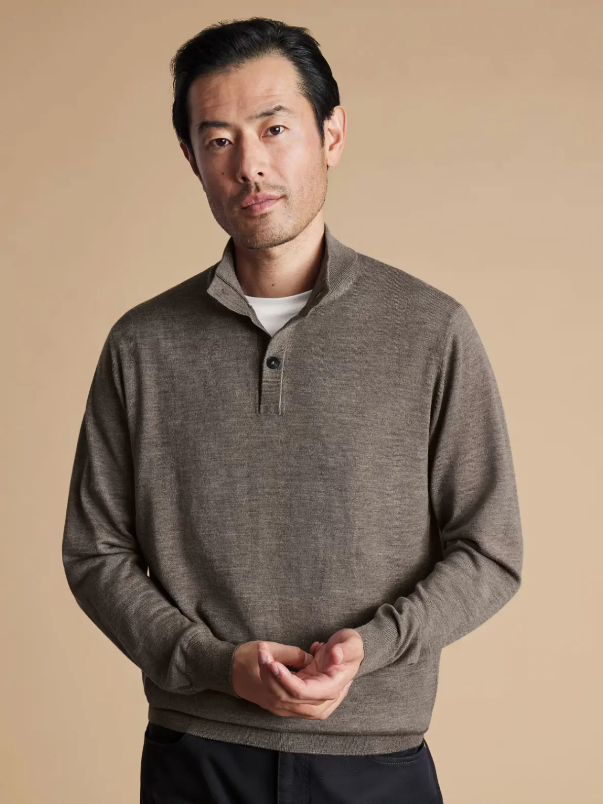 Man wearing brown jumper layered over white T-shirt