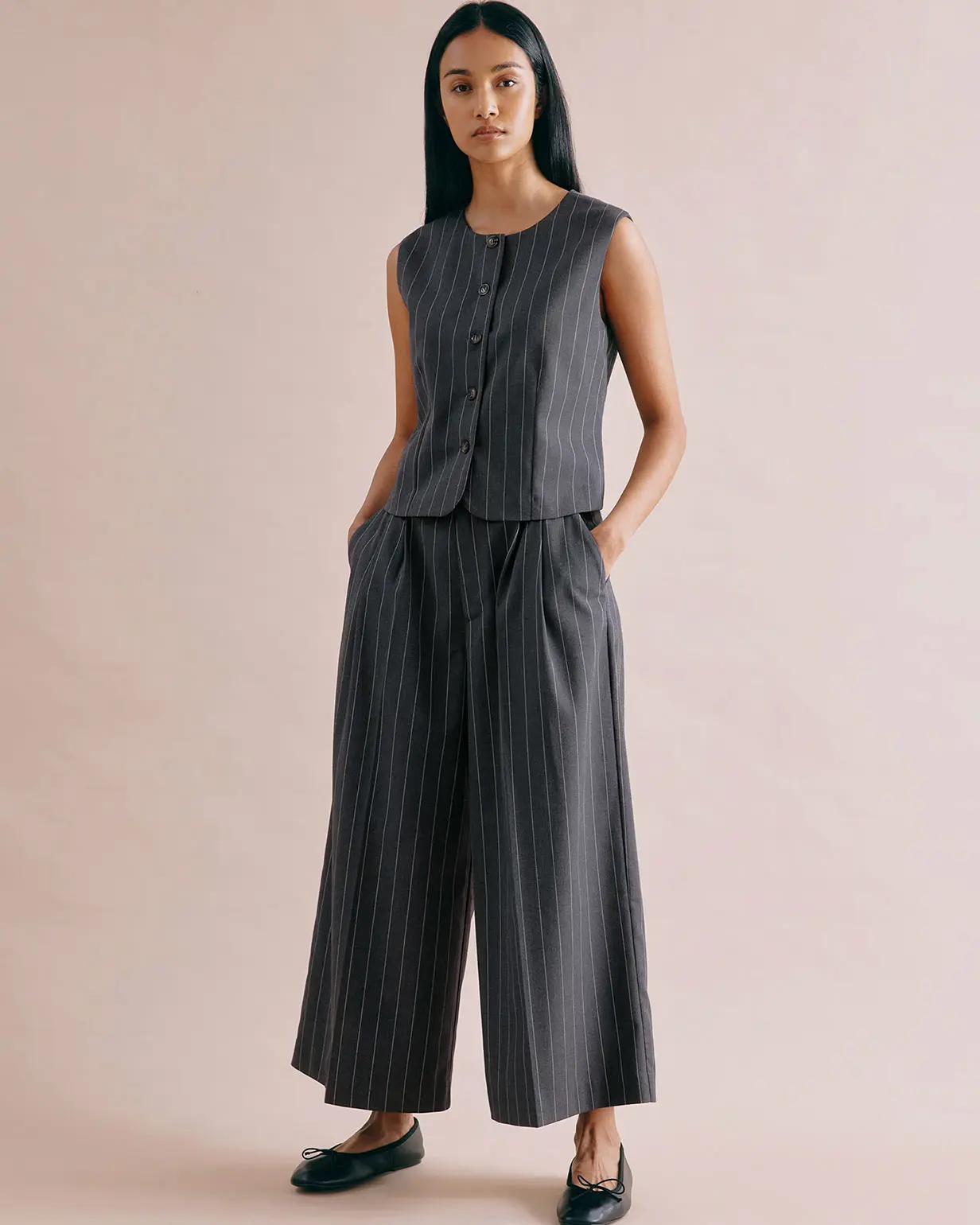 Woman wearing matching pinstriped waistcoat and wide leg trousers