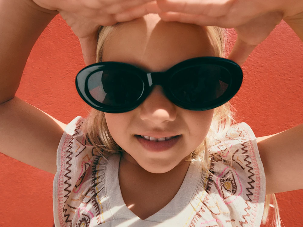 Girl wearing black sunglasses and an embroidered summer dress