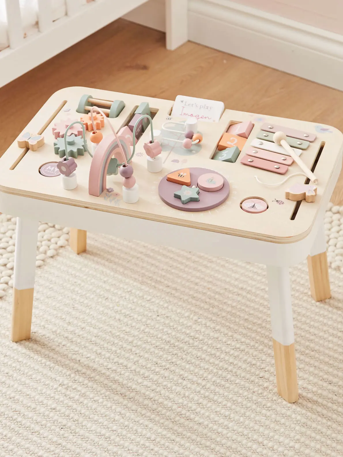 Wooden children's activity table with lilac, orange and baby pink pieces