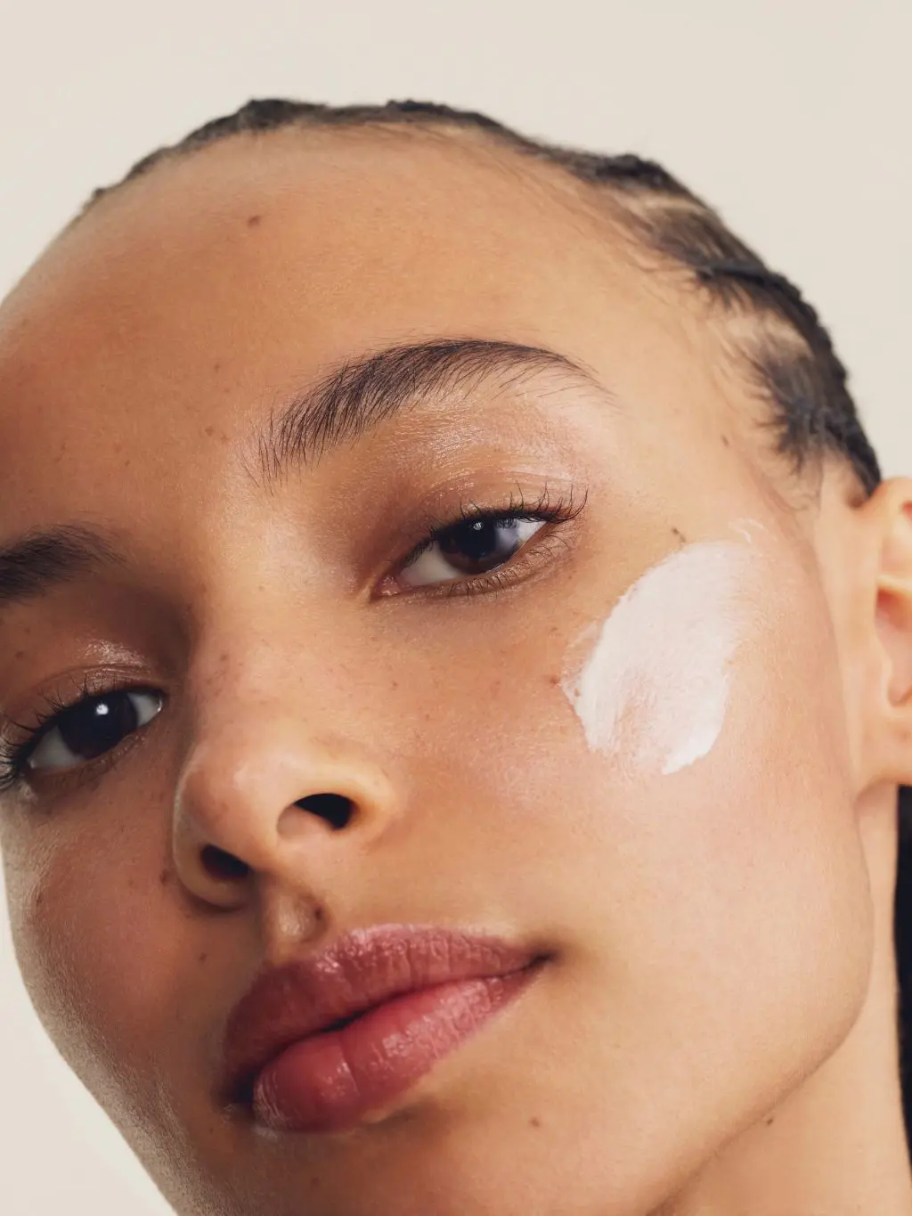 Woman with skincare products on face