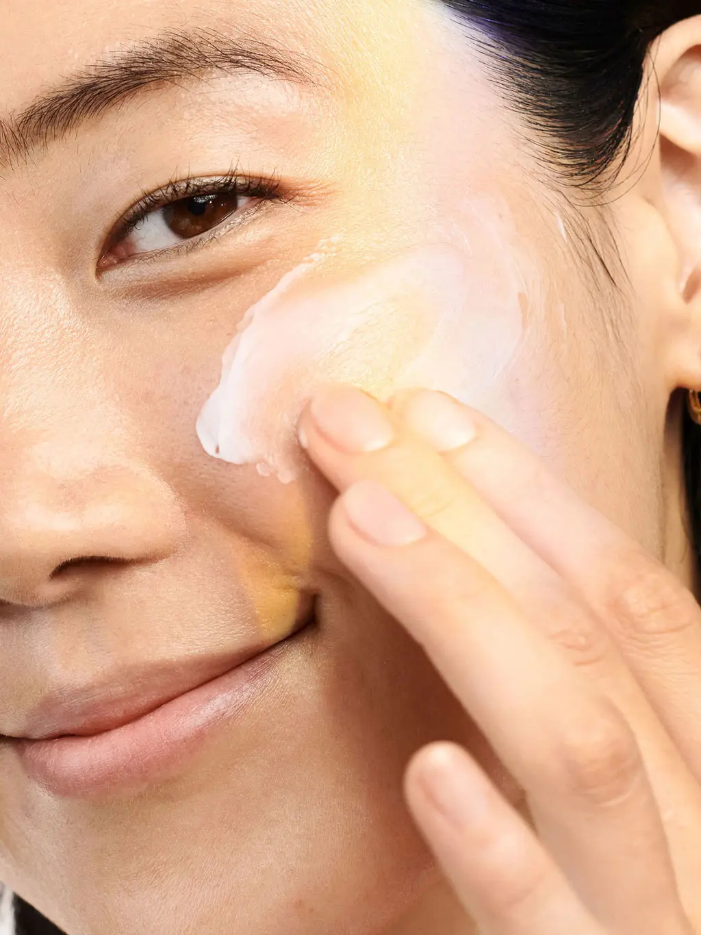 Woman applying a vitamin C cream