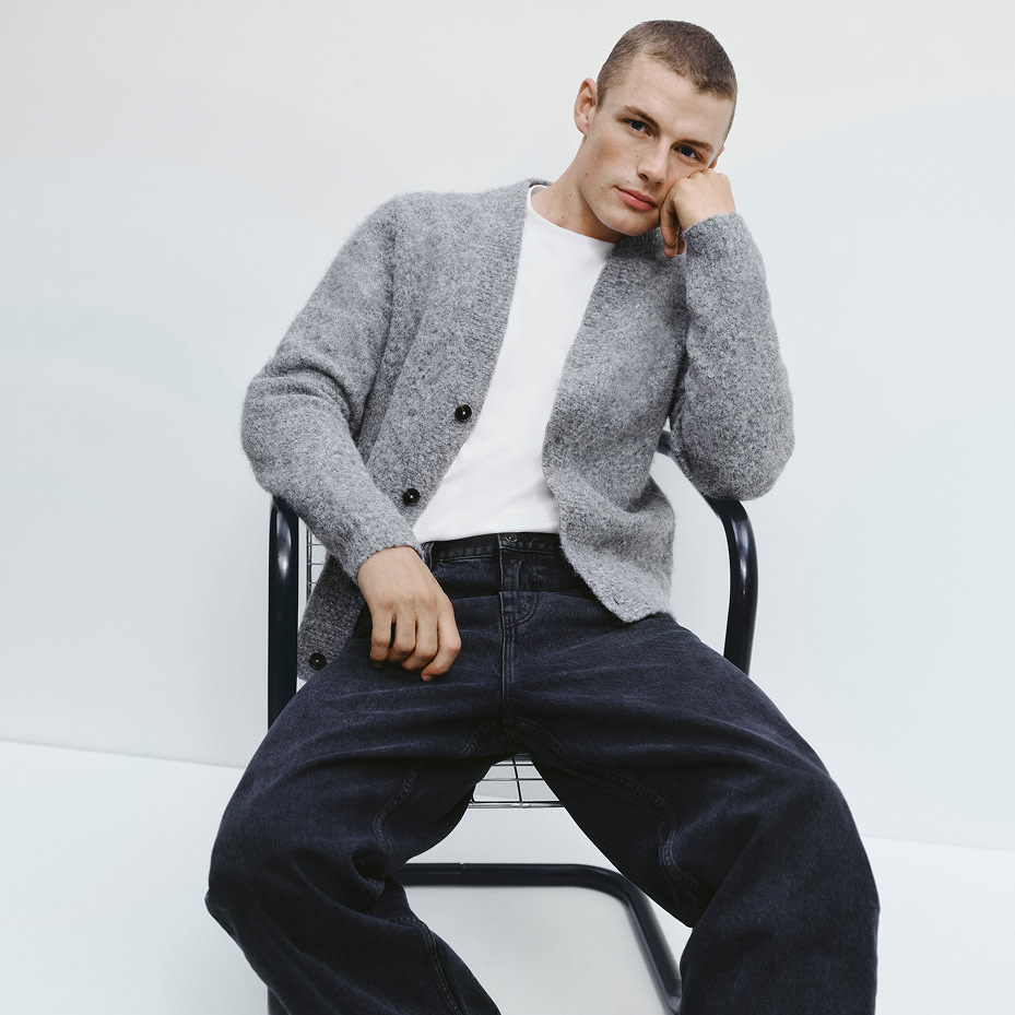 Man wearing grey cardigan, white T-shirt and indigo jeans