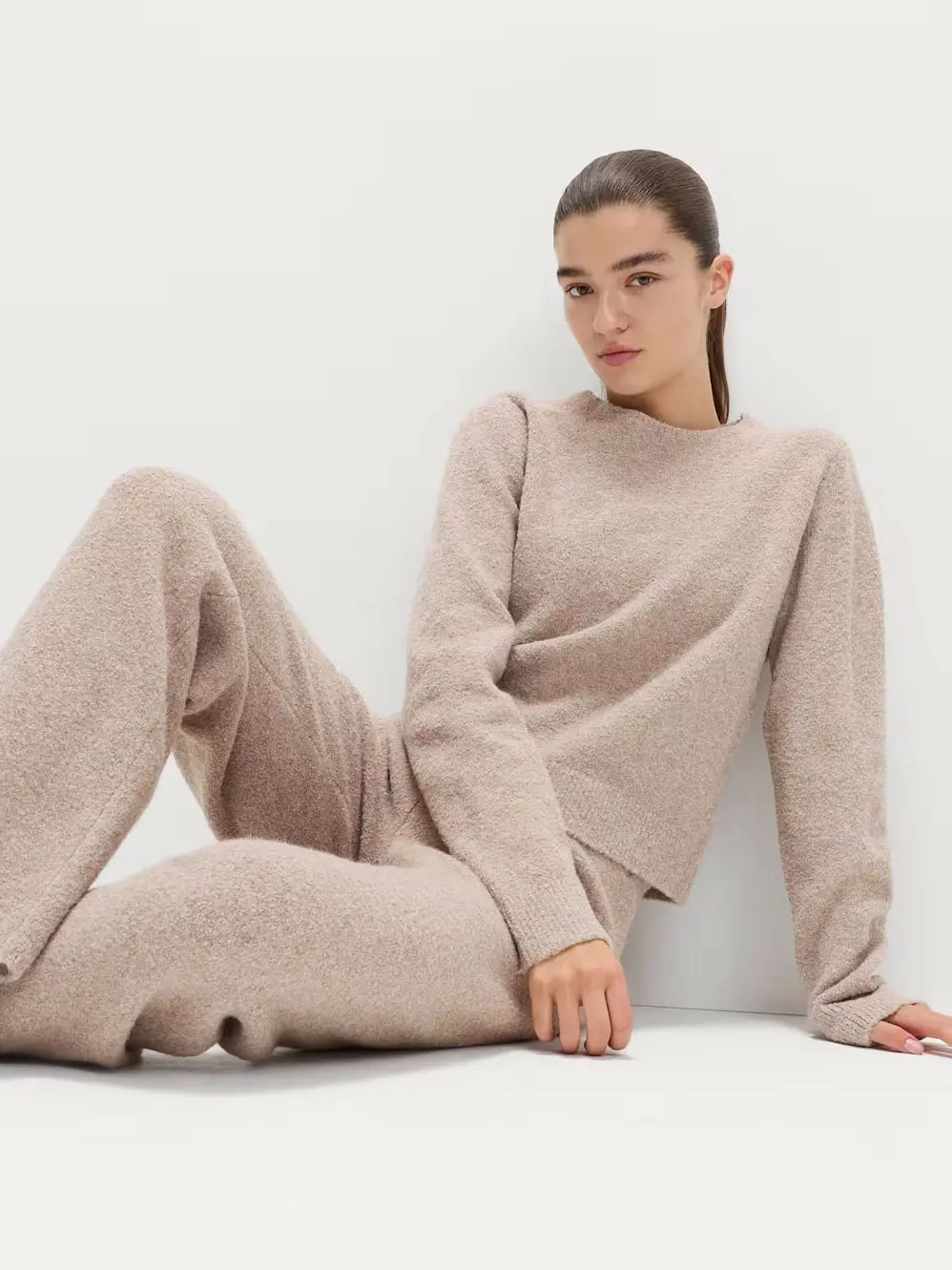 Woman wearing beige knitted jumper and trousers