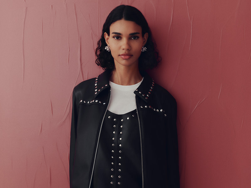 Woman wearing black leather coat with silver studs
