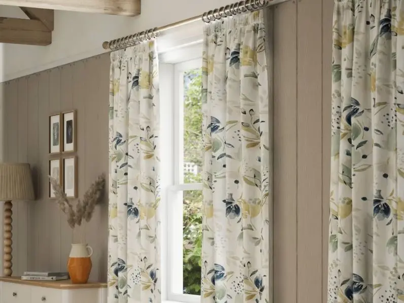 A lounge featuring grey walls and floral curtains
