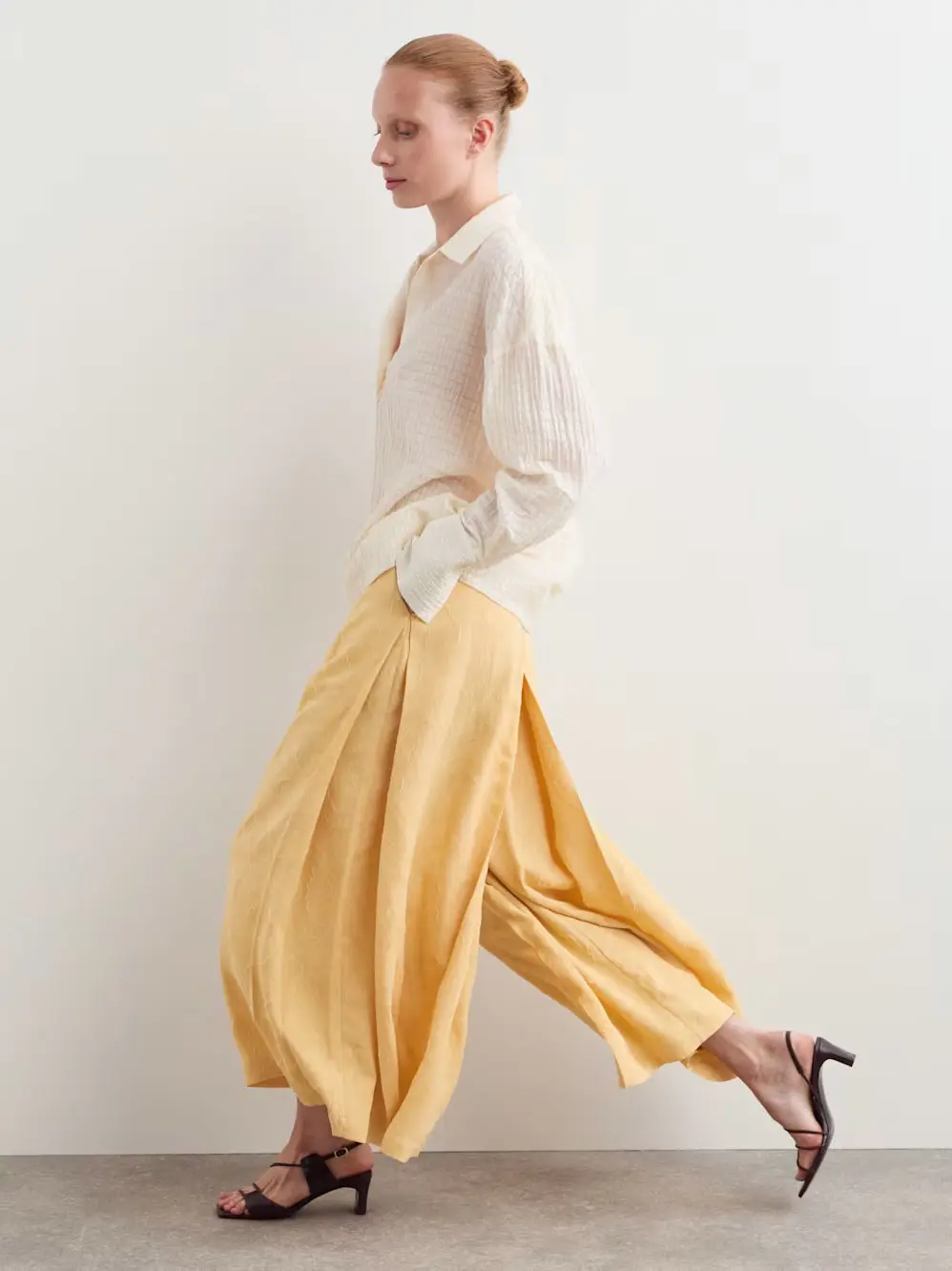 Woman in yellow trousers and white top