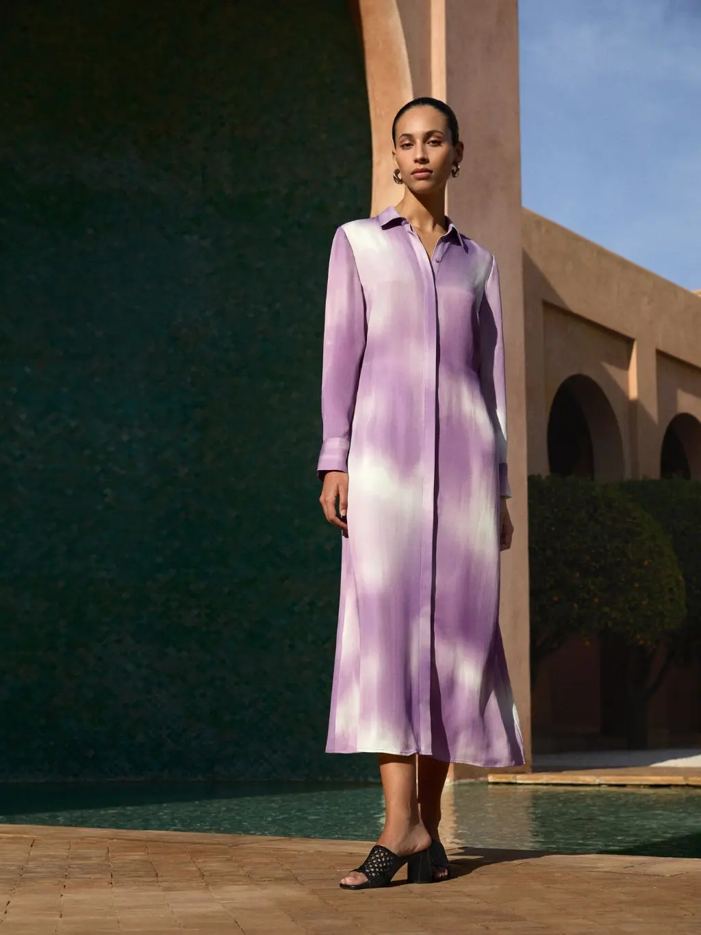 A woman wears a lilac and cream ombre shirt dress