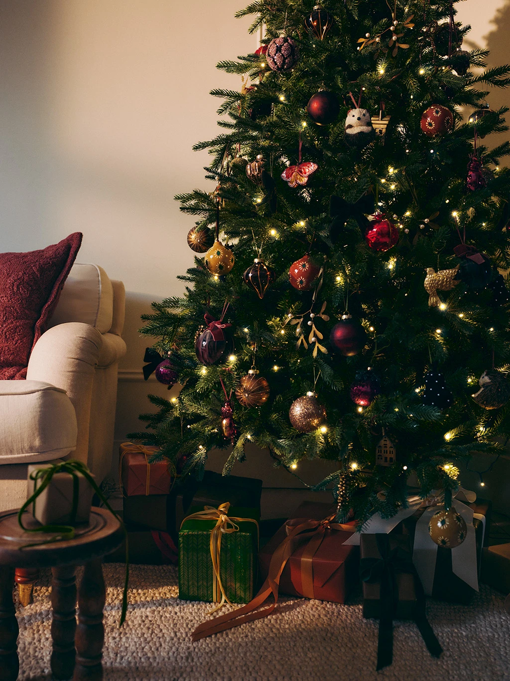 Christmas tree decorated with red and gold baubles with presents underneath.