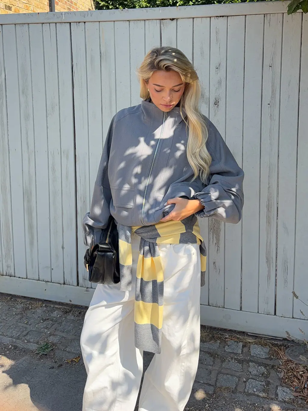 Woman in grey jacket and white jeans