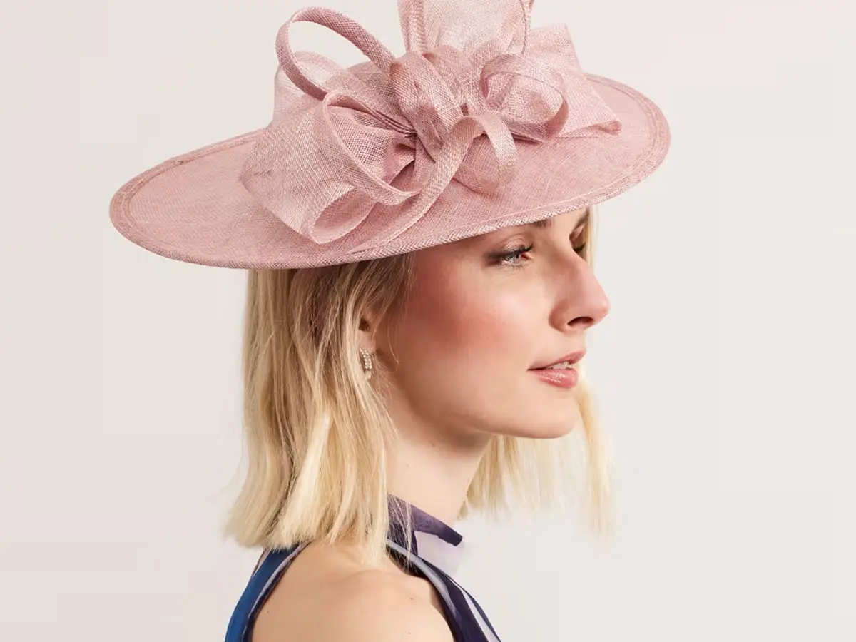 Woman wearing a pink fascinator with a blue dress