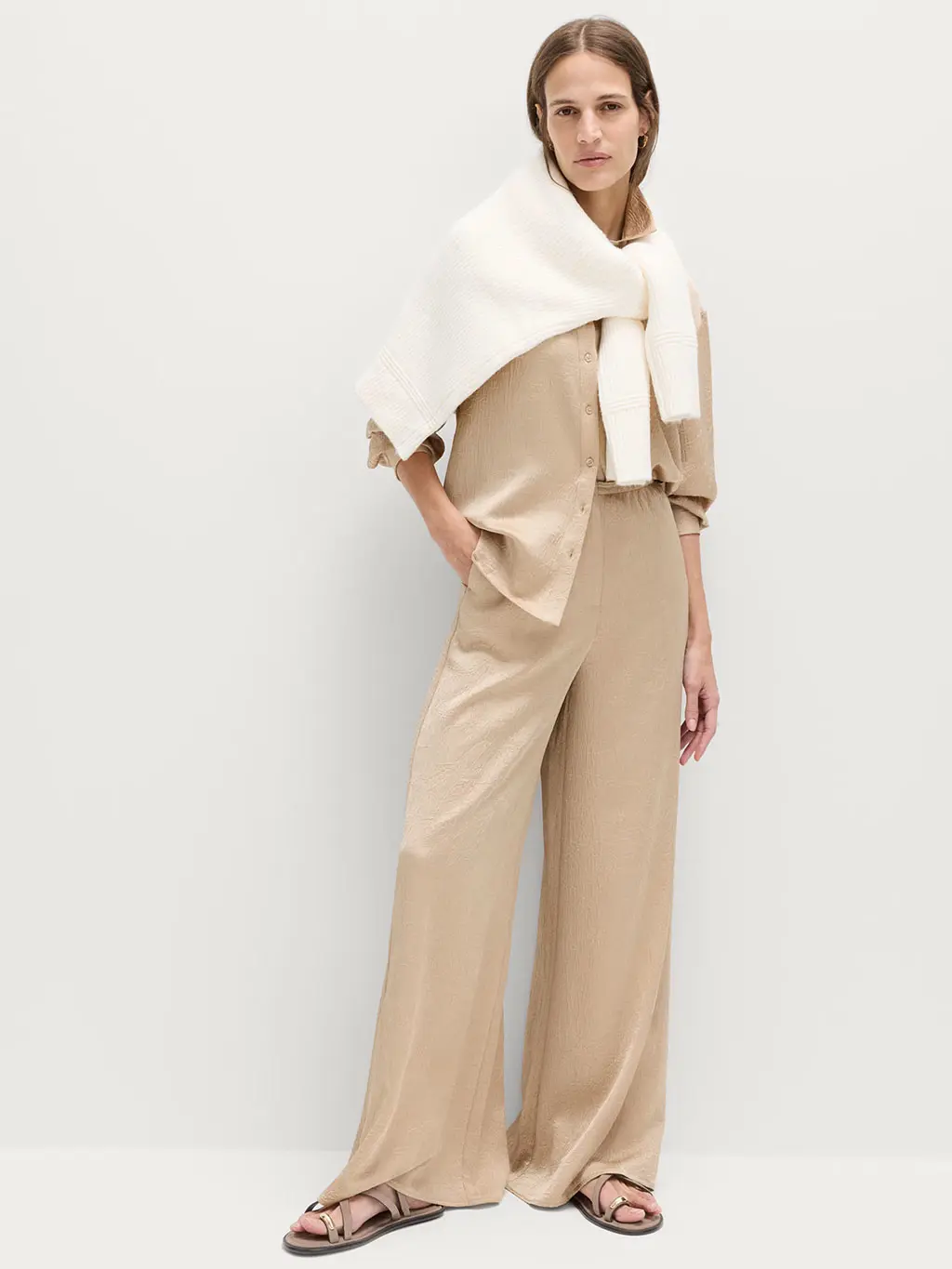 Woman in palazzo trousers and beige shirt