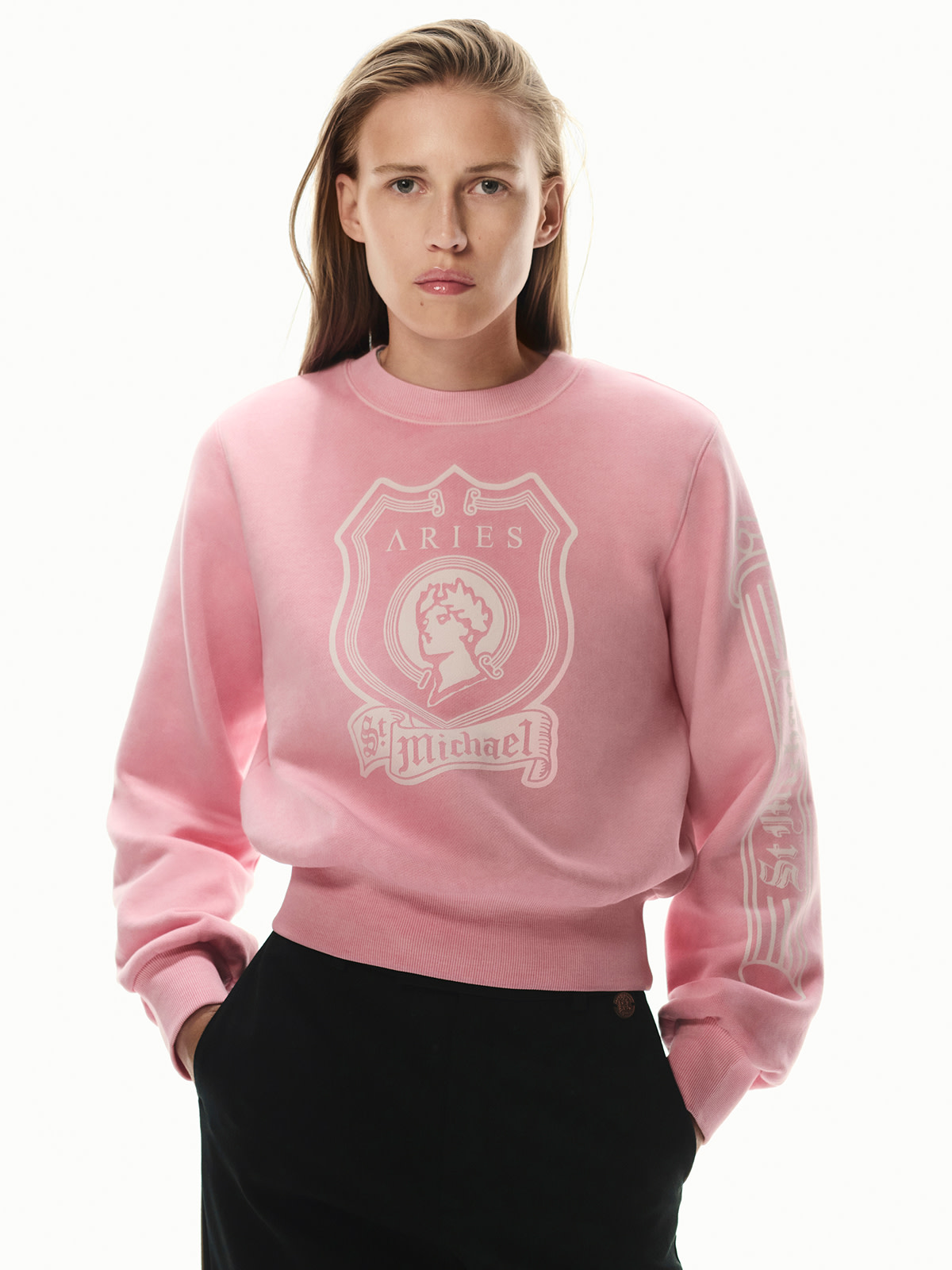 Girl wearing pink sweatshirt featuring white print logo