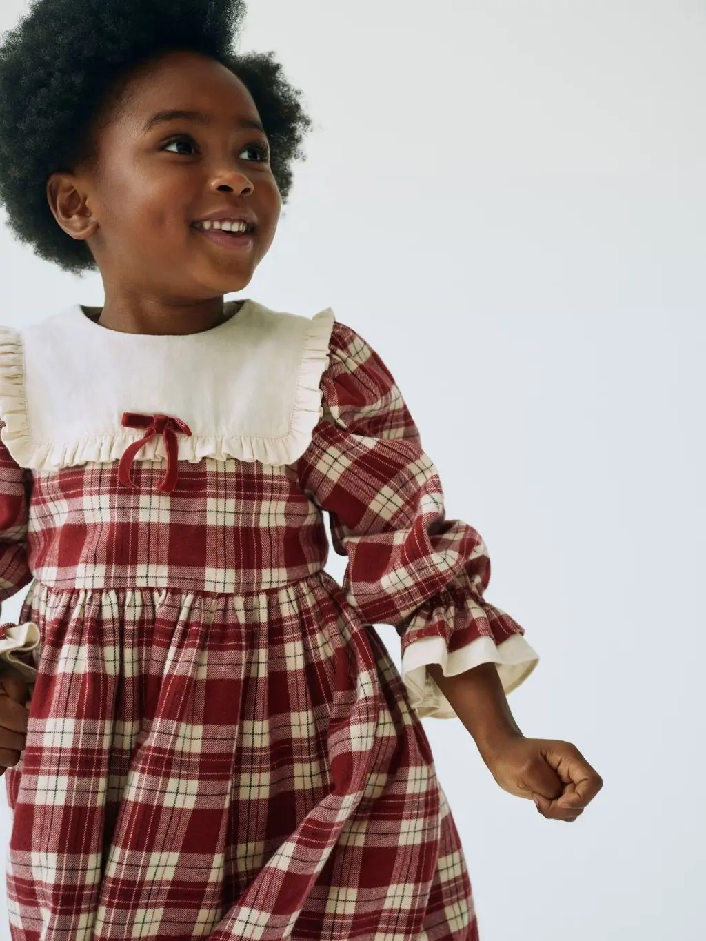 A little girl wears a tartan party dress