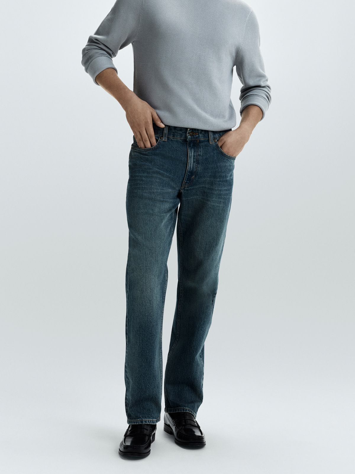 Man wearing straight fit jeans and grey jumper