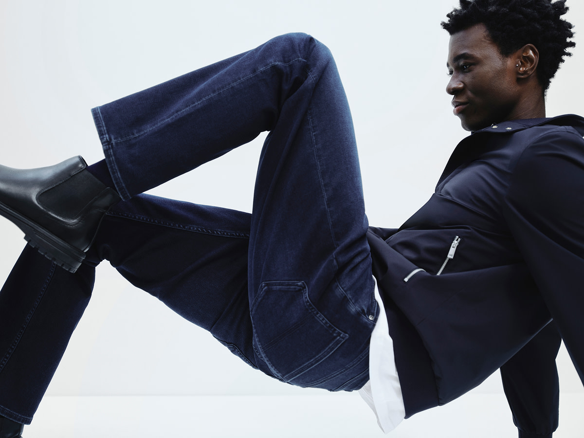 Man wearing navy jacket and dark-blue jeans