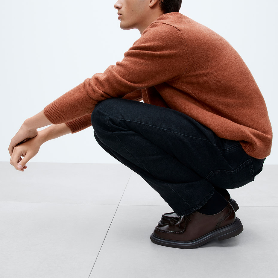 Man wearing ochre jumper and blue jeans