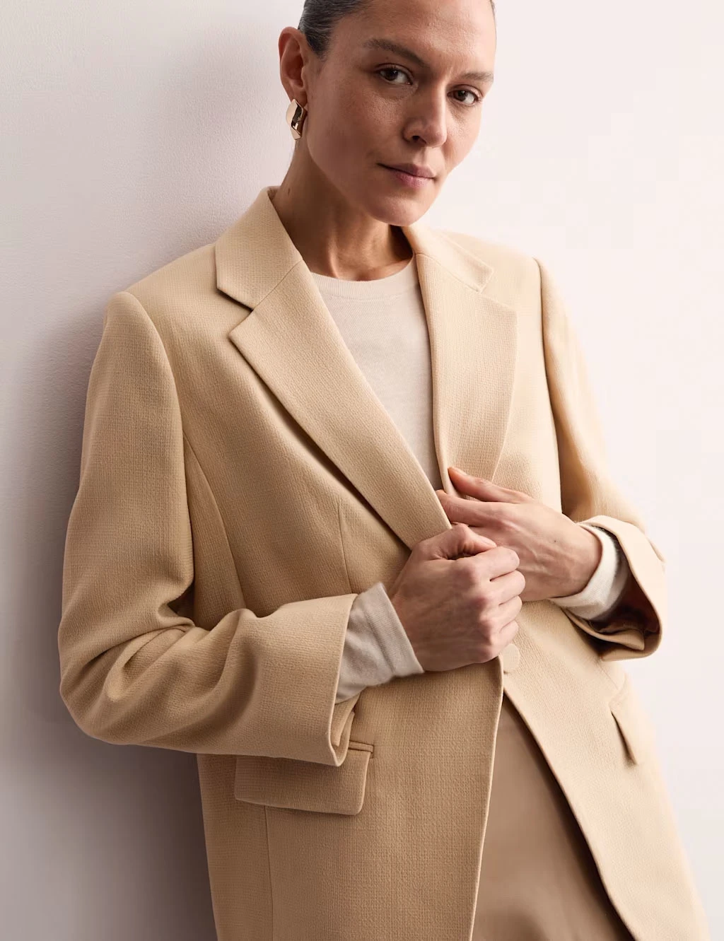 Woman wearing a beige blazer by Jaeger at M&S