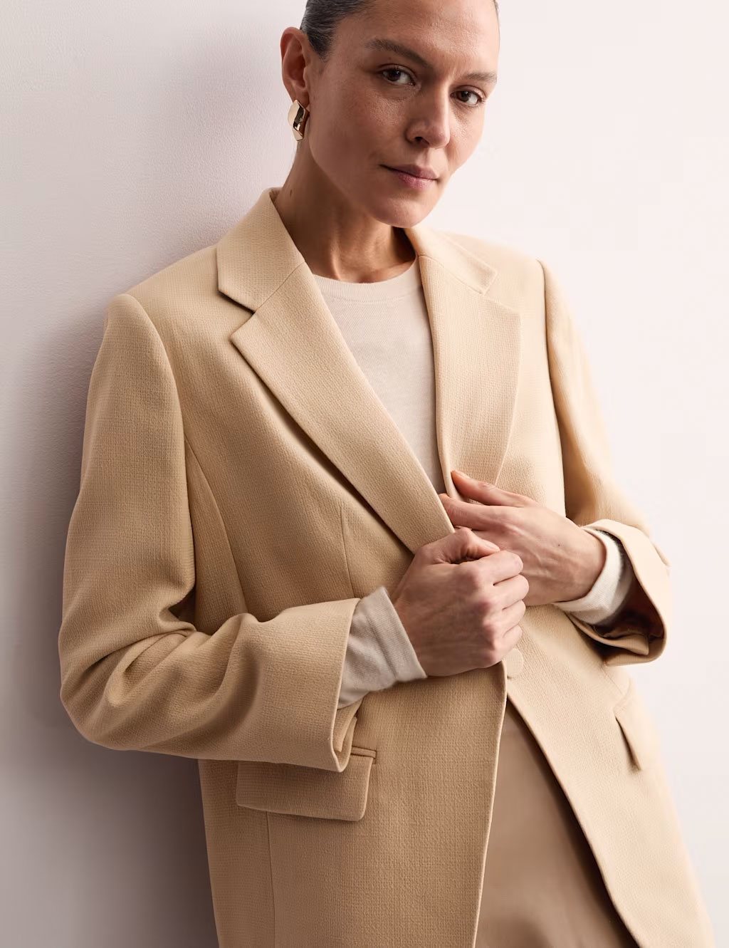 Woman wearing a beige blazer by Jaeger at M&S