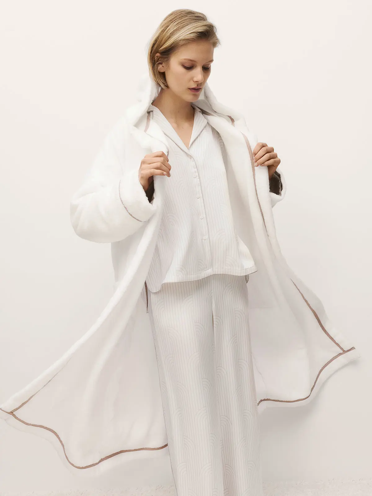 Woman wearing white pyjama set and dressing gown
